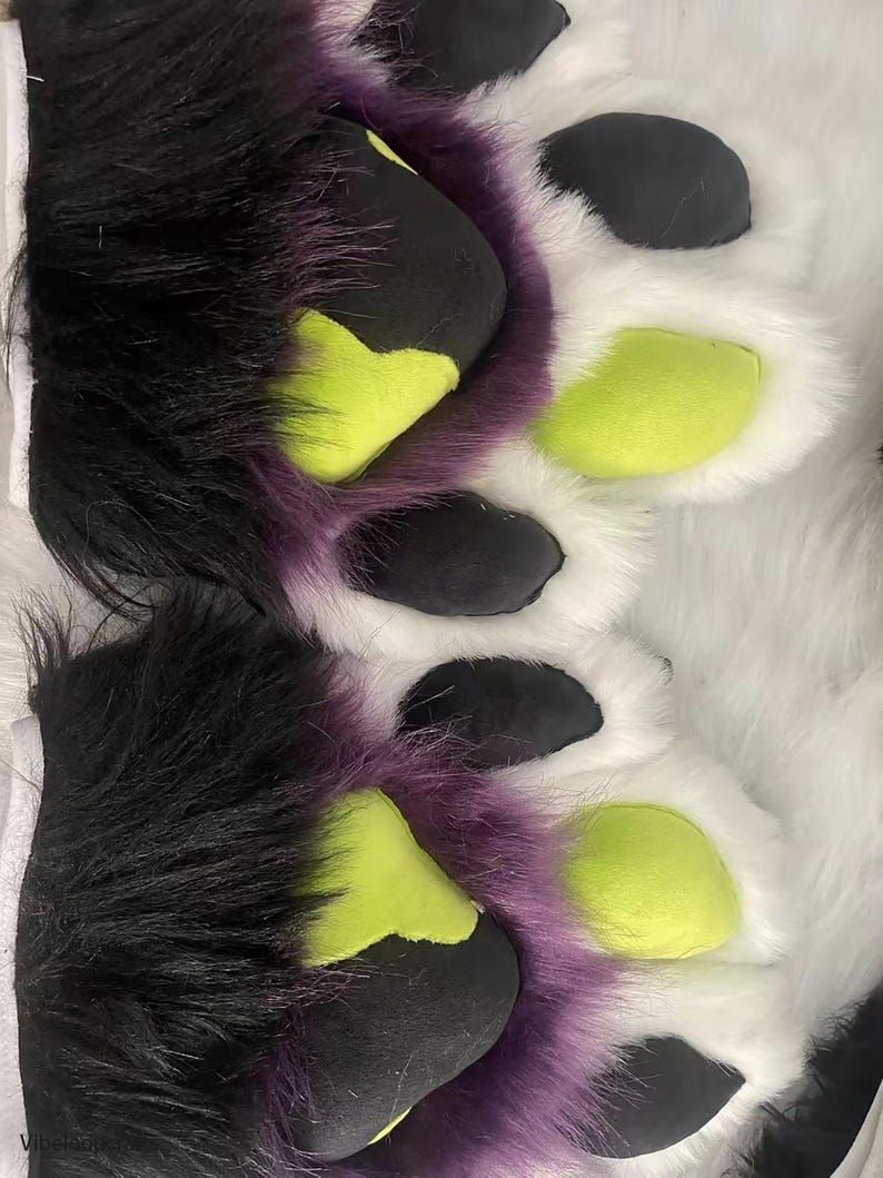 May include: A pair of furry paws with black, purple, and green accents. The paws are made of soft, plush fabric and have a realistic look.
