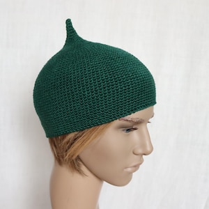 Puede incluir: Un gorro de punto verde oscuro con una parte superior puntiaguda. El gorro está hecho de un hilo suave y texturizado.