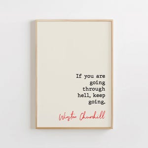 May include: A framed print with a white background and black text that reads "If you are going through hell, keep going." The text is attributed to Winston Churchill in red lettering.