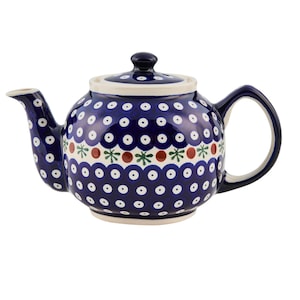 Könnte beinhalten: Eine blaue und weiße Tupfen-Teekanne mit einem grünen und roten Blumendesign um die Mitte. Die Teekanne hat einen runden Körper und einen Ausguss auf der linken Seite.