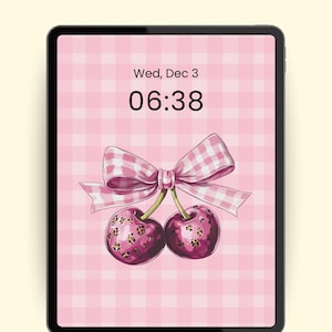Puede incluir: Una pantalla de iPad muestra un fondo de pantalla rosa a cuadros con un lazo y cerezas. El texto "PREPPY IPAD WALLPAPER" está en la parte superior. La fecha y la hora se muestran: Mié, 3 de dic, 06:38. La resolución es de 2800 x 2800.