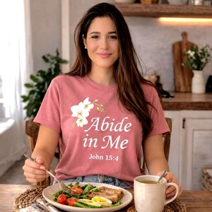 Christian woman wearing floral abide in me shirt cozy home faith outfit relaxing moment