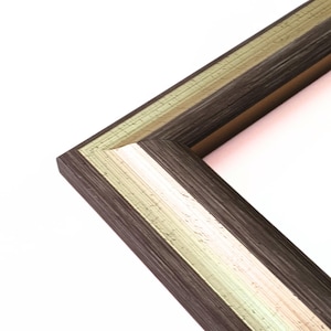 May include: Close-up of a corner of a picture frame with a dark brown wood finish and a gold and white trim.