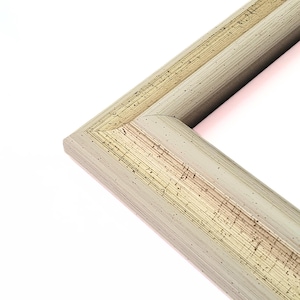 May include: A close-up of the corner of a light beige picture frame with a gold-toned inner edge. The frame has a textured surface.