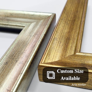 May include: Two wooden picture frames, one with a gold finish and the other with a silver finish. The gold frame has a custom size available, as indicated by the text "Custom Size Available" and the Arta Atelier logo.