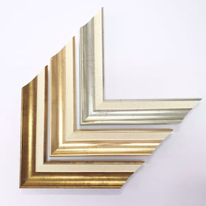 May include: Five picture frames in different sizes and colors, arranged in a pyramid shape. The frames are made of wood and have a distressed finish. The colors are gold, silver, and white.