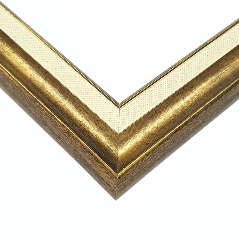 May include: A gold picture frame with a white mat. The frame has a decorative, ornate design.