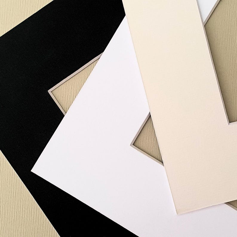 May include: Three different colored mat boards with a beveled edge. The mat boards are black, white, and cream.
