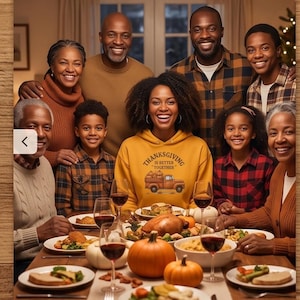 A large family gathers around a festive dinner table for Thanksgiving while a woman in the center wears a yellow hoodie with a truck graphic.