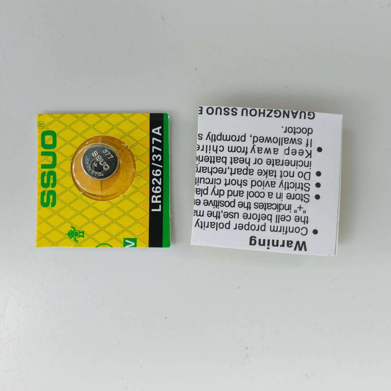 May include: A small, round LR626/377A battery cell in a yellow and green package. The package has the brand name "SSUO" and warning information. A separate white card provides safety instructions.