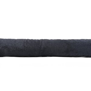 May include: A long, dark grey bolster pillow. The pillow is made of a soft, textured fabric.