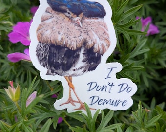 May include: A sticker depicting a detailed illustration of a bird with brown, black, and blue plumage. The sticker includes the text "I Don't Do Demure" in a handwritten style. The sticker is set against a backdrop of green foliage and pink flowers.