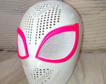 Puede incluir: Una máscara facial completa de color blanco con una textura perforada en la frente y la barbilla. La máscara incluye dos grandes aberturas oculares en forma de almendra delineadas con un borde rosa neón, con una malla blanca sobre cada ojo.