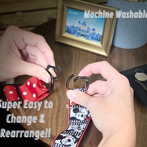 May include: Two hands are shown connecting a black metal clasp to a red and white polka dot ribbon and a black and white Mickey Mouse ribbon. The text "Super Easy to Change & Rearrange!!" is visible.