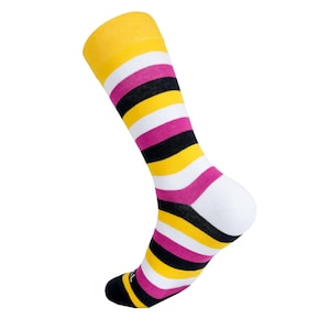 Peut inclure: Une paire de chaussettes rayées avec des rayures jaunes, blanches, noires et roses. Les chaussettes sont repliées au niveau du talon et la pointe est visible.