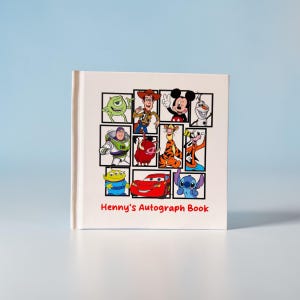 May include: A white autograph book featuring a collage of Disney characters, including Mickey Mouse, Woody, and Stitch. The title "Henny's Autograph Book" is printed in red at the bottom. The book is square and has a clean, simple design.