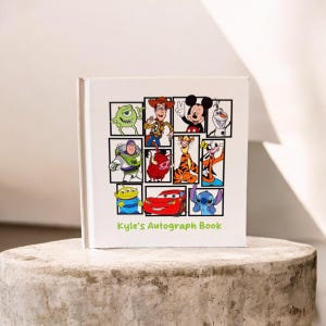 May include: White autograph book featuring cartoon characters like Mickey Mouse, Buzz Lightyear, and Stitch. The cover has a grid of character images and the text "Kyle's Autograph Book" in green.