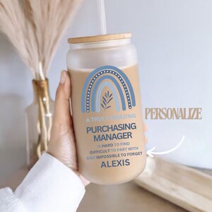 May include: A frosted glass tumbler with a bamboo lid and a straw. The tumbler has a blue and white rainbow design with a leaf and the text "A truly amazing Purchasing Manager is hard to find, difficult to part with and impossible to forget, Alexis".