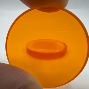 Peut inclure: Un couvercle en plastique orange vif avec un plus petit couvercle en plastique orange à l'intérieur. Les couvercles sont translucides et ont une surface lisse.