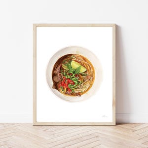 Puede incluir: Una ilustraci&oacute;n de acuarela de un taz&oacute;n de pho vietnamita, una sopa de fideos tradicional. El taz&oacute;n est&aacute; lleno de caldo, fideos, carne y hierbas frescas. El pho est&aacute; adornado con una rodaja de lima y chiles rojos.