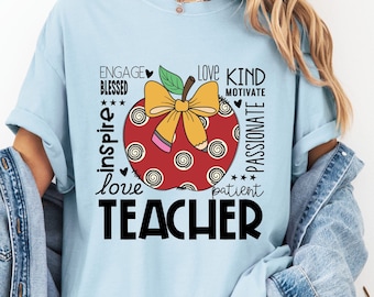 May include: A light blue t-shirt with a red apple graphic and the text "Engage, Blessed, Inspire, Love, Teacher, Kind, Motivate, Patient, Passionate".