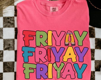 Może przedstawiać: Różowa koszulka z napisem "FRIYAY" w kolorowych blokowych literach. Litery zaprojektowano z grafiką o tematyce szkolnej, w tym ołówkiem, jabłkiem i linijką. Jest to plik do pobrania cyfrowego.