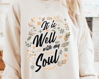 May include: A white sweatshirt with a floral design and the text "It is Well with my Soul".