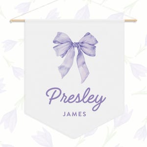 May include: A white banner with a purple bow and the name "Presley James" written in purple script.