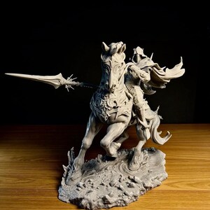 Può includere: Scultura grigia dettagliata di un cavaliere a cavallo, con una lancia. Il cavallo è al galoppo, con un'armatura intricata e una criniera fluente. La scultura è su una base strutturata, con uno sfondo scuro.