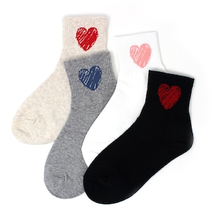 May include: Four pairs of ankle socks in various colors: beige, gray, white, and black. Each sock features a scribbled heart design in red, blue, pink, and red. The socks are made of a soft, ribbed material.