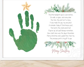 May include: A framed print featuring a green handprint with a gold star and festive text. The handprint is painted in green, with a poem about Christmas and a message that reads "Merry Christmas". The print is in a white frame.