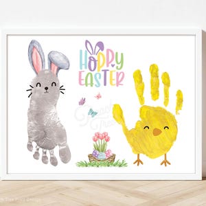 Può includere: Una cornice bianca con un coniglio grigio e un'impronta di mano di pulcino giallo. Il testo "Hoppy Easter" è scritto in colori arcobaleno.