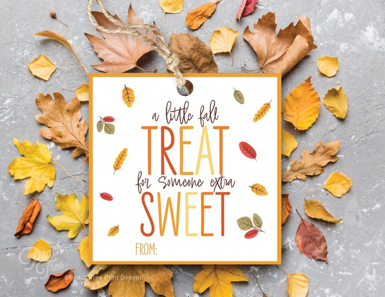 Op de afbeelding: Een geel en oranje cadeau-etiket met de tekst "a little fall treat for someone extra sweet" en ruimte voor een naam. Het etiket is omringd door herfstbladeren.