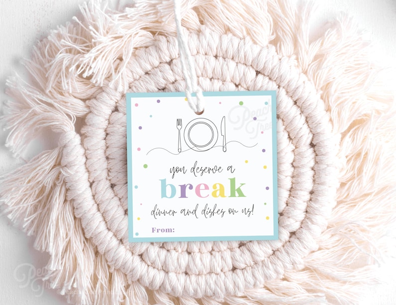 May include: A blue gift tag with colorful confetti and a black and white illustration of a plate and fork. The text on the tag reads "You deserve a break, dinner and dishes on me!" with a space for a name under "From:"