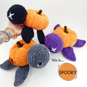 Peut inclure: Trois jouets en forme de tortue en crochet en forme de citrouille. L'un est noir, l'autre violet et l'autre orange. La tortue orange a une croix blanche sur sa carapace. Le texte "This is... SPOOKY" est écrit sous les tortues.