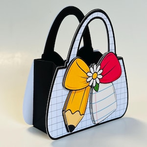 May include: A decorative paper handbag with black handles and a white grid pattern. The bag features a yellow pencil, a red bow, and a white daisy. A lined paper design is also visible on the front of the bag.