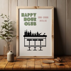 May include: A white framed poster with black text that reads "HAPPY HOUR CLUB" in a retro font. The text "Sunday - Saturday 5PM till late" is in a smaller font below the main text. A black silhouette of a bar counter with three stools is below the text.