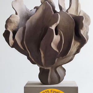 Peut inclure: Sculpture abstraite aux tons bruns et beiges, évoquant une fleur stylisée, posée sur un socle en béton. L'œuvre est finaliste des Etsy Design Awards 2025. La forme est organique et fluide.