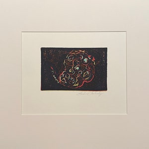 Op de afbeelding: Een zwart-witte print van een abstract ontwerp met rode, groene en blauwe accenten. De print is getiteld "Andre Czekeley".