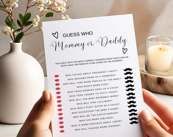 May include: A white card with black text and red lips and black mustaches. The card is a game for a baby shower called "Guess Who Mommy or Daddy?" The card has a list of questions about pregnancy and parenting.