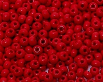 May include: A large quantity of small, round, red beads. The beads are made of glass and have a smooth, shiny finish.