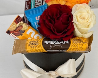 Geschenkbox mit veganen Snacks und frischen Rosen