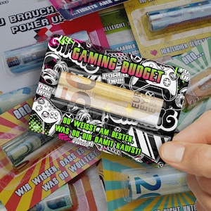 Könnte beinhalten: Eine Sammlung von Geschenk-Artikeln, jeweils in durchsichtigem Kunststoff verpackt. Die Verpackung zeigt verschiedene Designs, darunter Gaming-Grafiken mit dem Text "GAMING BUDGET" und andere Sätze. Die Artikel scheinen aufgerolltes Geld zu sein.