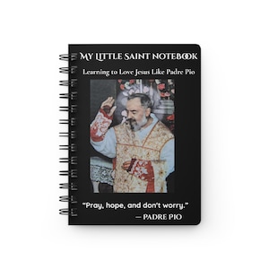 May include: A black spiral-bound notebook featuring the text MY LITTLE SAINT NOTEBOOK and Learning to Love Jesus Like Padre Pio at the top. The center displays a photograph of Padre Pio in vestments, with the quote Pray, hope, and don't worry. — PADRE PIO at the bottom.