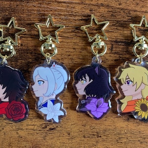 Puede incluir: Cuatro llaveros acrílicos con perfiles de personajes de estilo anime. Cada llavero tiene un cierre dorado en forma de estrella. Los personajes tienen diferentes colores de cabello y detalles florales: una rosa roja, un lirio blanco, una flor morada y un girasol.