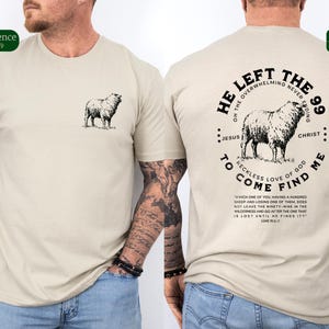 May include: A beige t-shirt with a black and white illustration of a sheep on the front and a circular design on the back. The design features a sheep, the words "He Left the 99", "On the Overwhelming Never Ending", "Jesus", "Christ", "To Come", "Reckless Love of God", "Find Me", and a quote from Luke 15:3-7.