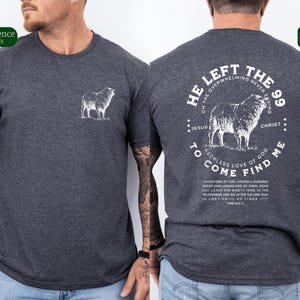 May include: A dark gray t-shirt with a white graphic on the back. The graphic features a sheep and the text "He left the 99... to come find me."  The text also includes the words "Jesus" and "Christ".