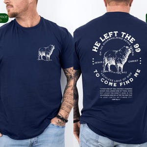 May include: Navy blue t-shirt with a white graphic of a sheep on the front and a white graphic of a sheep and text on the back. The text reads "He left the 99 on the overwhelming never ending... Jesus... Christ... To come find me... Reckless love of God... "Which one of you having a hundred sheep and losing one of them, does not leave the ninety-nine in the wilderness and go after the one that is lost until he finds it?" Luke 15:3-7