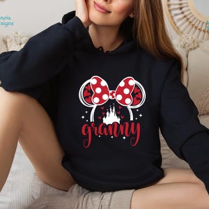 K&ouml;nnte beinhalten: Schwarzer Hoodie mit einem roten und wei&szlig;en Minnie Mouse-Ohren-Design und dem Wort "granny" in wei&szlig;en Buchstaben.