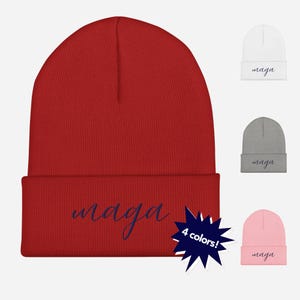 May include: Red, gray, white, and pink knit beanie with the word "maga" written in cursive on the front. The beanie is available in four colors.